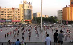В Китае редко когда можно услышать музыку. И все же в этот вечер на площади Син-Мина было довольно шумно. А множество женщин самого разного возраста старательно выполняли какие-то упражнения, следуя указаниям инструкторов.